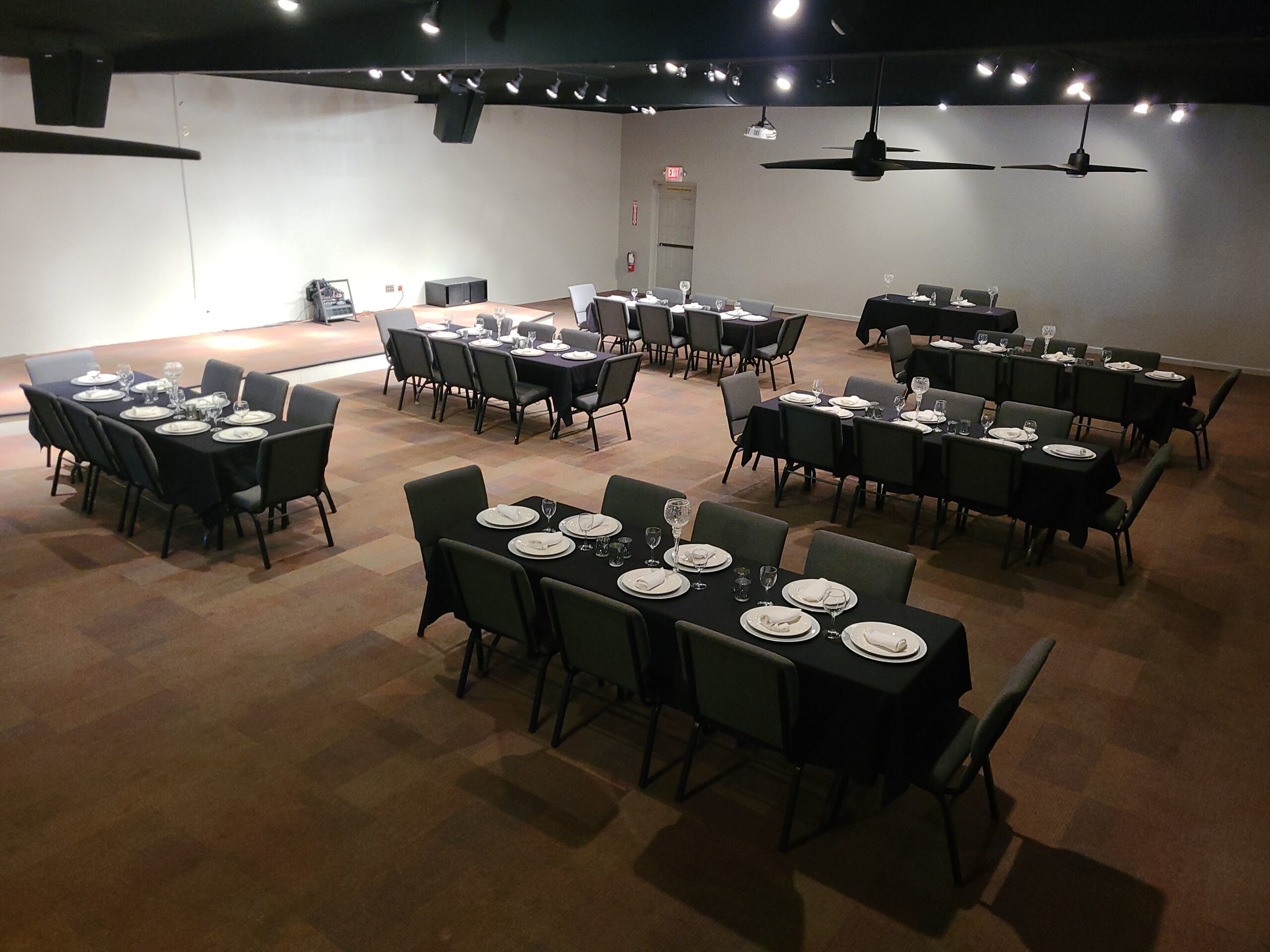 Wide shot photo of the upstairs main hall, with 6 long tables.