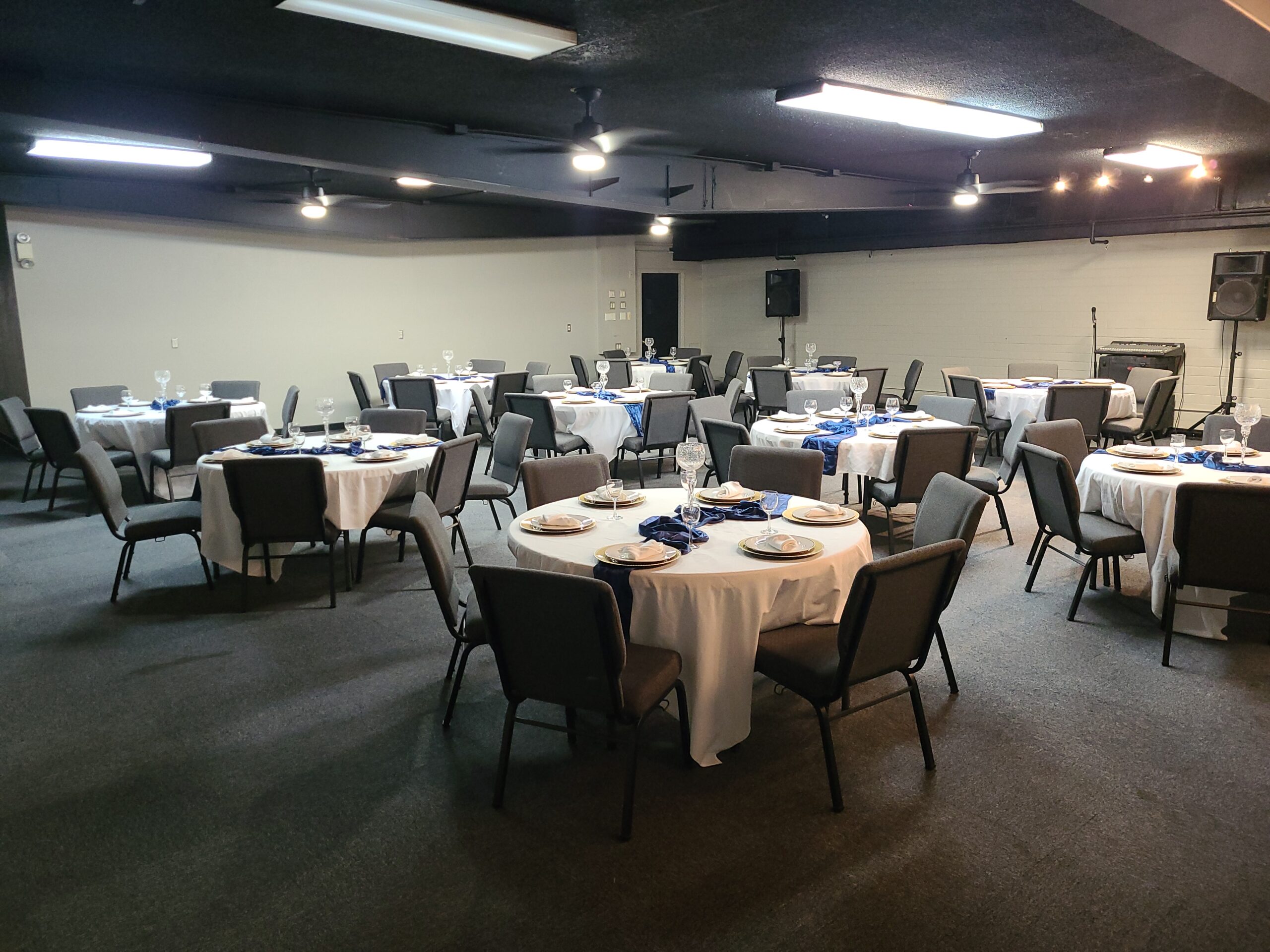 Wide shot photo of the downstairs main hall, with round tables.