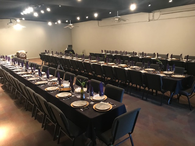 Wide shot photo of the upstairs main hall, with long tables.